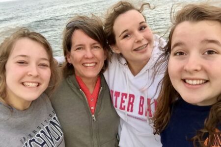 Mom and daughters in front of water