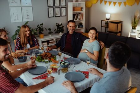 holiday dinner table friends pregnant woman