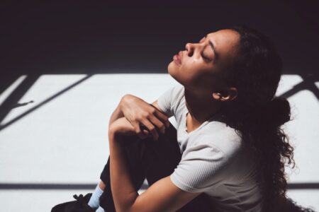 Young woman hugging her knees in tears