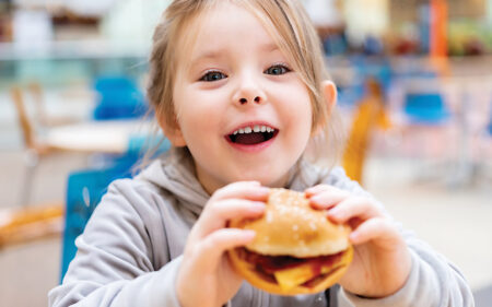 child eating hamburger