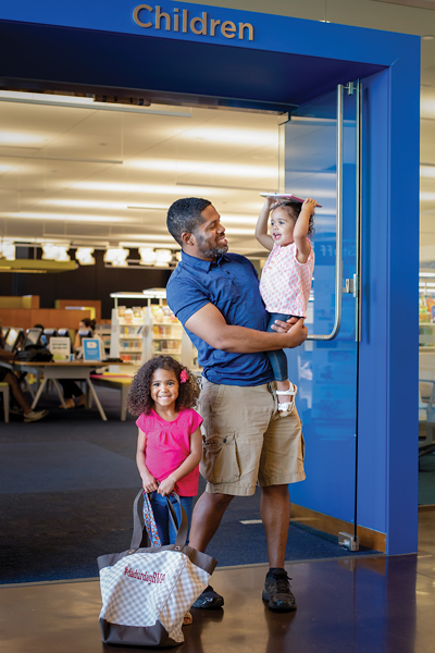 Dad with two daughters at the library