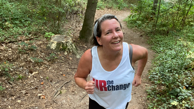 middle-aged woman running on a trail