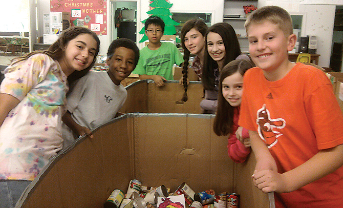 Kids around a food bank collection box