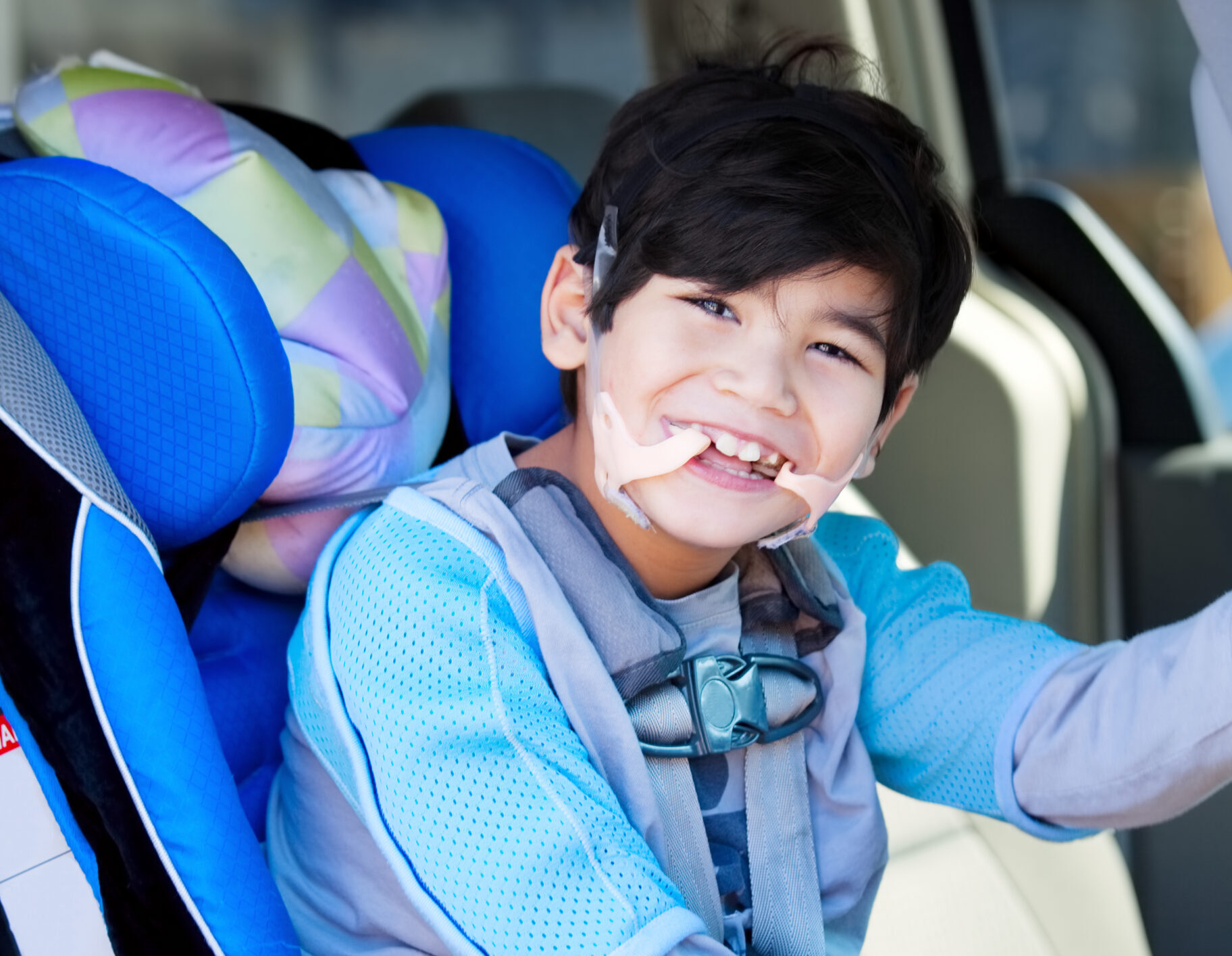 A six year old boy with disabilities in a car seat