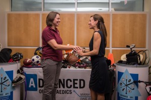 Logan Ferguson, relationship manager for Advanced Orthopaedics, hands the keys to the room full of sports equipment to Mary Dunne Stewart, executive director of Greater Richmond Fit4Kids.